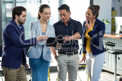 Businesspeople discussing over digital tablet