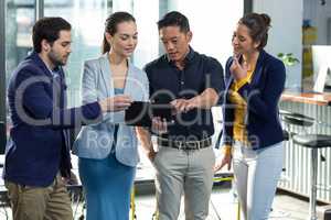 Businesspeople discussing over digital tablet