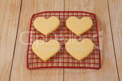 Four heart shaped cookie kept on cooling tray