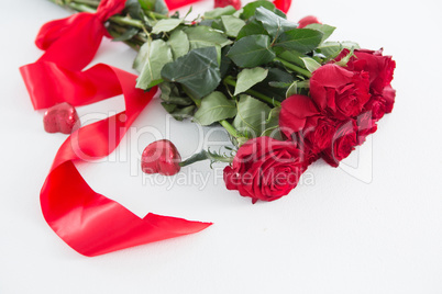 Bunch of red roses surrounded with heart shape chocolate
