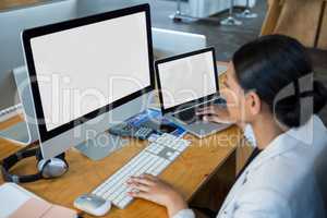 Businesswoman working over computer and laptop
