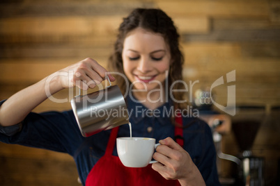 Smiling waitress making cup of coffee