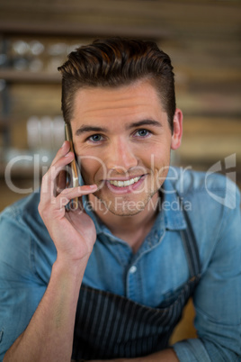 Portrait of waiter talking on mobile phone in cafÃ?Â©