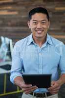 Portrait of smiling businessman using digital tablet