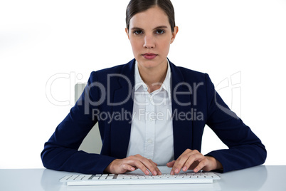 Portrait of businesswoman typing on keyboard at desk