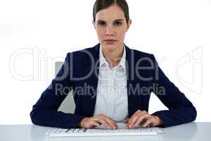 Portrait of businesswoman typing on keyboard at desk