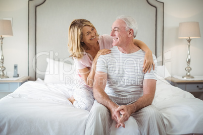 Smiling woman embracing man on bed