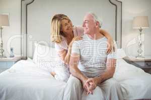 Smiling woman embracing man on bed
