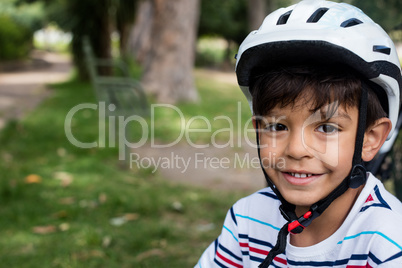 Portrait of smiling boy wearing bicycle helmet in park
