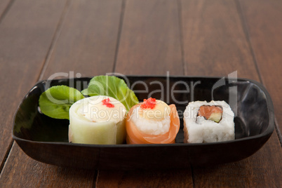 Nigiri and uramaki sushi served on black boat plate