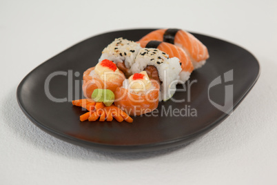 Maki, uramaki and nigiri sushi served in black plate