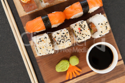 Assorted sushi set served with chopsticks and soy sauce on wooden board