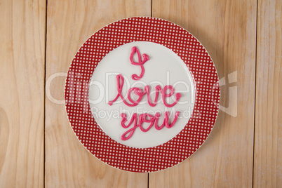 I love you text written with pink cream on plate