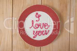 I love you text written with pink cream on plate