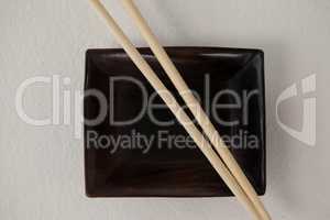 Pair of chopsticks over a bowl