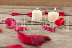 Burning candles surrounded with aromatic rose petals