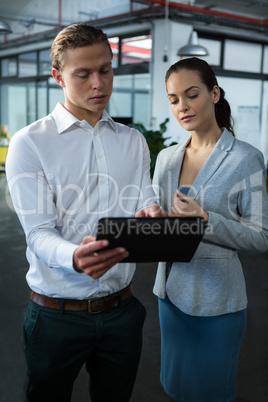 Business executives discussing over digital tablet