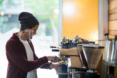 Owner making cup of coffee in espresso machine