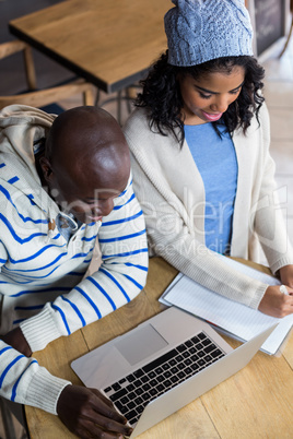 Smiling couple using laptop