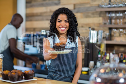 Waiter serving a cup cake at counter