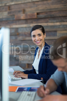 Portrait of smiling businessman working on personal computer