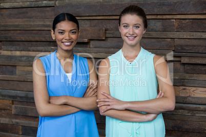 Business executives standing with arms crossed in office