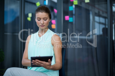 Graphic designer sitting on chair and using digital tablet