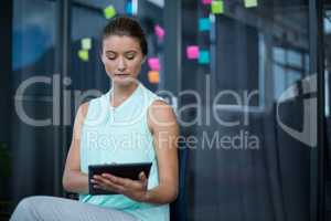 Graphic designer sitting on chair and using digital tablet