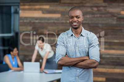 Business executive standing with arms crossed in office