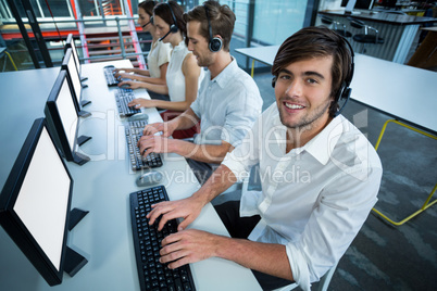 Business executives with headsets using computer