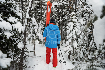 Skier walking with ski on snow covered mountains