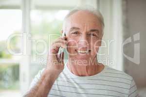 Portrait of happy senior man talking on mobile phone