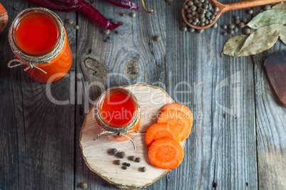 Fresh carrot juice in glass jars, top view