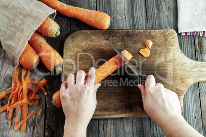 process of cutting slices of carrot on a kitchen wooden board