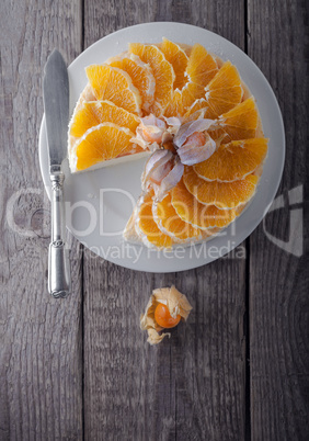 Cheesecake decorated with oranges and physalis.