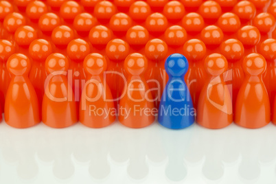 Conceptual orange game pawns and a blue game pawn