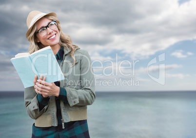 Composite image of Woman with book in front of sea