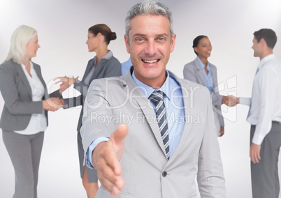 Composite image of Handshake in front of business people with white background