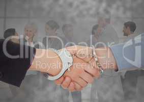 Handshake with handcuffs in front of business people with grunge overlay