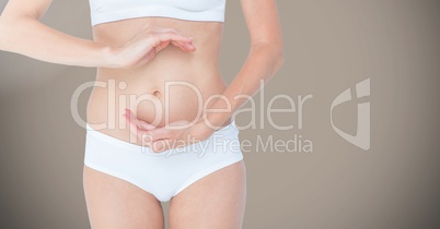 Woman torso showing her navel against brown background