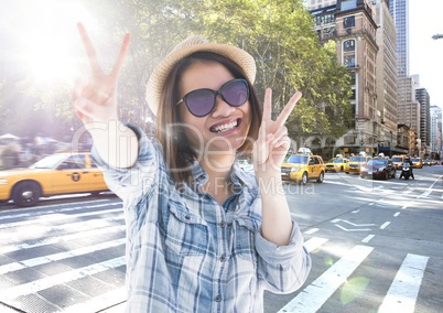 Composite image of Woman doing peace sign on street with flare