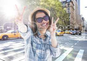 Composite image of Woman doing peace sign on street with flare