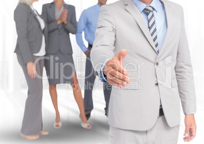 Handshake in front of business people in office