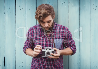 Composite image of Man with camera against blue wood panel