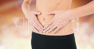 Woman torso showing her navel against lights background