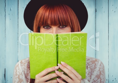 Woman with green book against blue wood panel