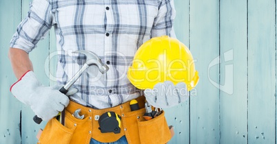 Carpenter torso with hammer against blue wood panel