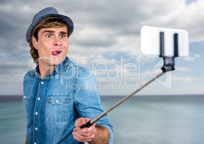 Man with selfie stick in front of sea