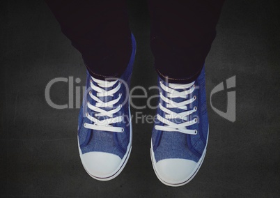Blue shoes on concrete against a black floor