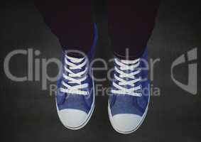 Blue shoes on concrete against a black floor